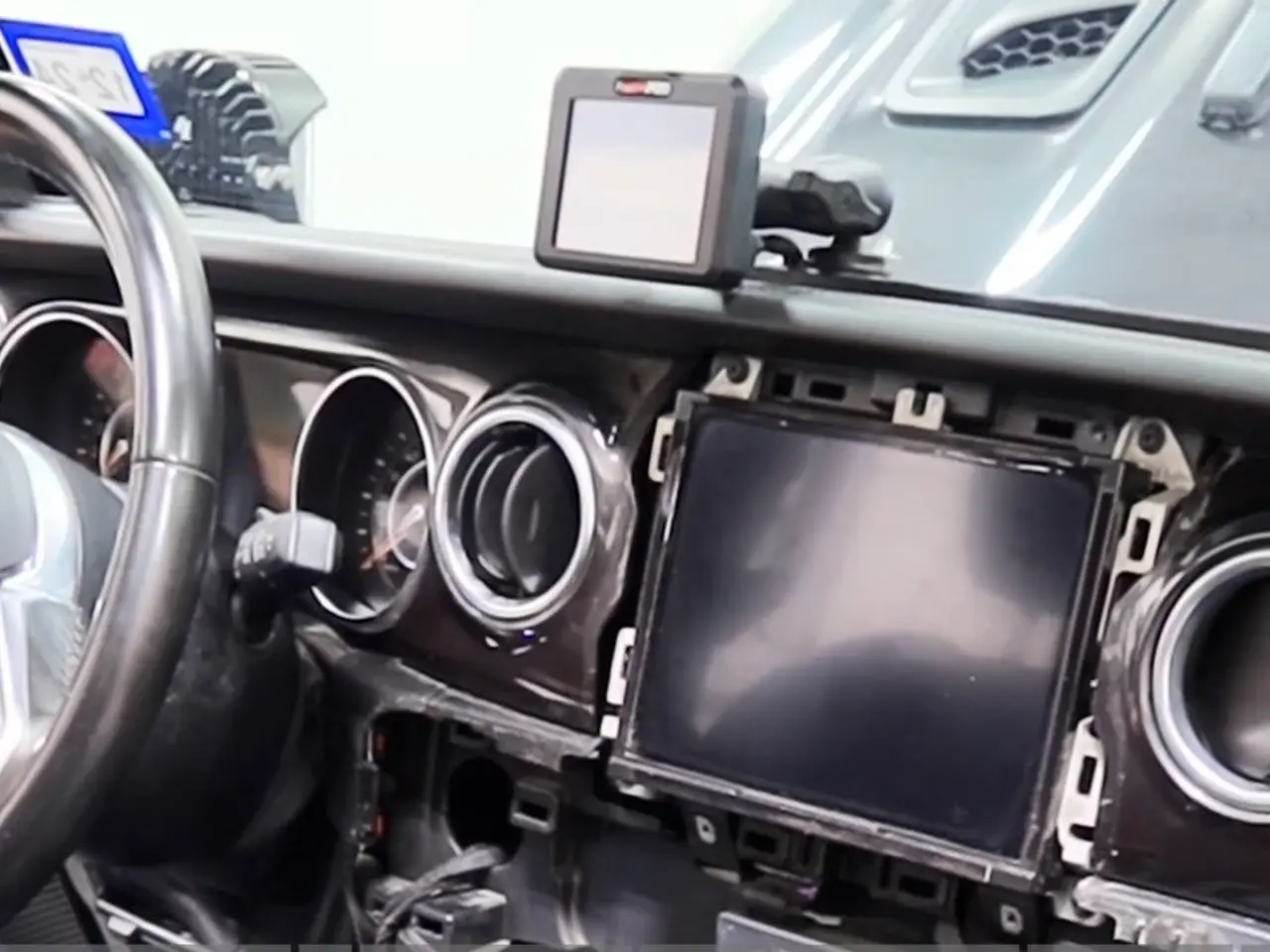 Jeep dash opened up during an OEM+ audio and factory screen upgrade